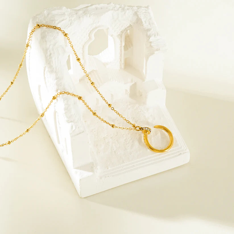 CSENGE Gold Necklace: Zirconia Embedded Circular Nail Pendant on a Satellite Beaded Chain
